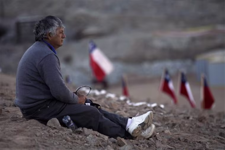 Oscar Illanes, 51, brother of one of the trapped miners, Juan Illanes, sits outside the collapsed San Jose mine in Copiapo, Chile, Saturday, Aug. 28, 2010. The miners, who have been trapped since the shaft they were working in collapsed on Aug. 5, were confirmed to be alive Sunday when they were reached by rescue teams via a small hole through which they could pass messages and see the miners with a camera. (AP Photo/Roberto Candia)
